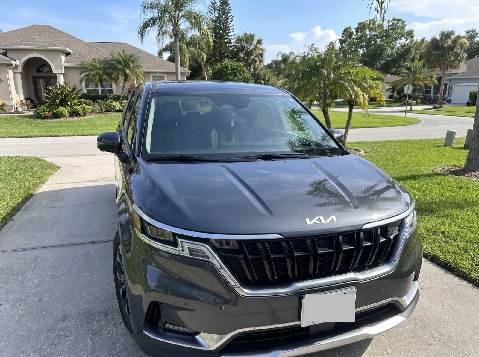 A dark grey minivan in a driveway in Palm Harbor, FL, after a Bang AutoGlass mobile glass job