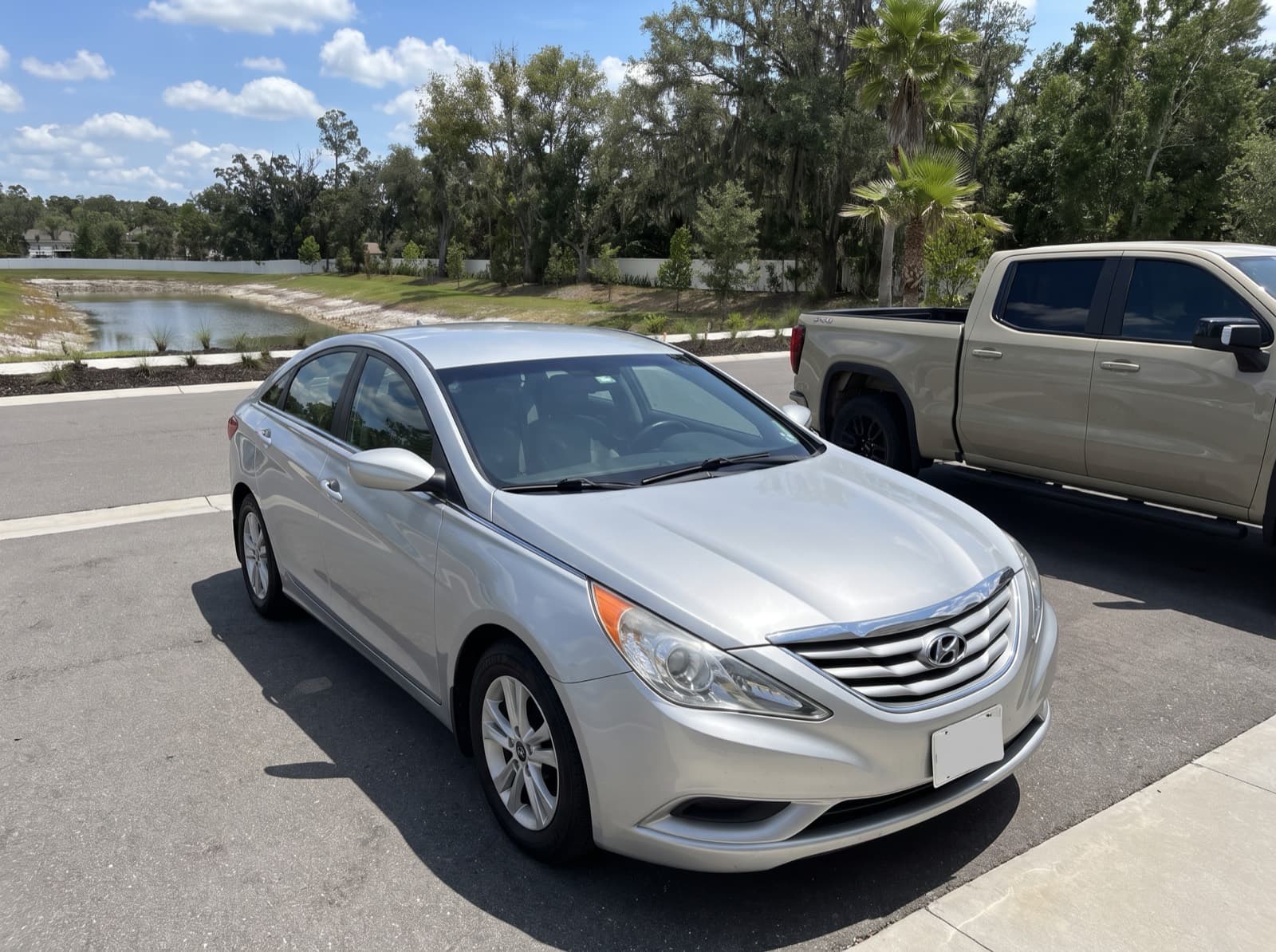 A silver sedan in a driveway in Wesley Chapel, FL, after a Bang AutoGlass mobile glass job