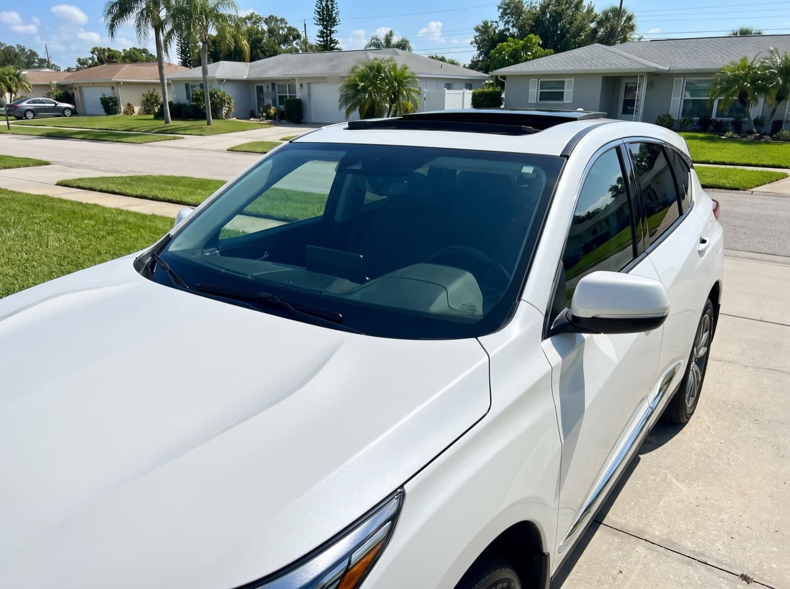 A white hatchback with a sunroof in a driveway in Clearwater, FL, after a Bang AutoGlass mobile glass job
